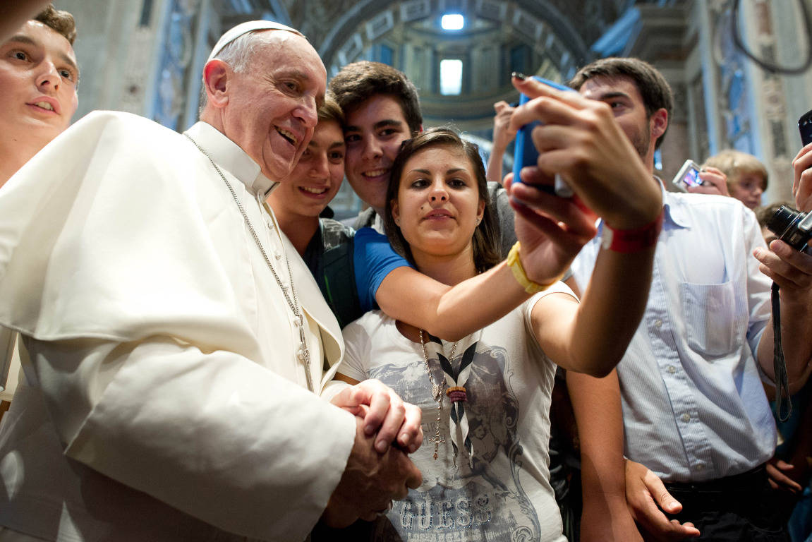 Pope Francis posing for a "selfie" with young people at the Vatican.